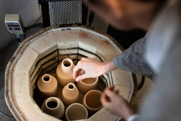 Potter placing pieces in a kiln for firing